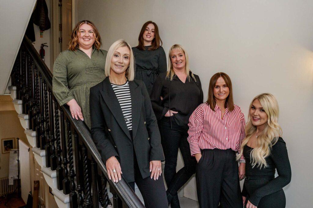 a photo of the Fitwise Events Team standing on the stairs in the office